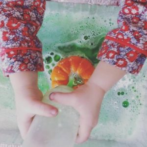 toddler using a sensory bin during fall STEM activities for early learning programs