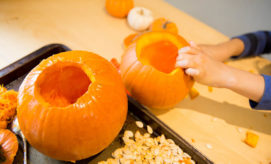 preschool child carving pumpkin during fall STEM activities for early learning programs