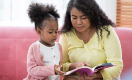 Early learning professional and preschool child reading together